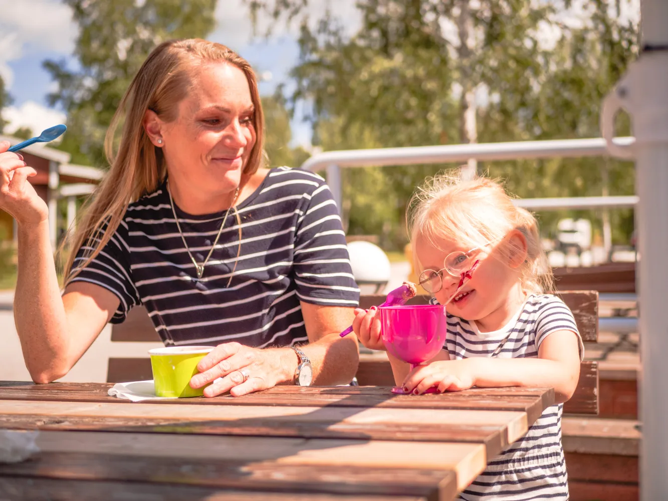 Familj med glass, sittandes vid bord utanför Cajsas Café